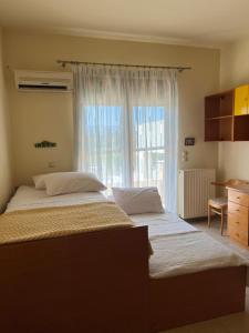 Schlafzimmer mit einem großen Bett und einem Fenster in der Unterkunft Luna's Summer House in Kremasti