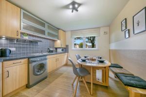 Links Road Apartment ✪ Grampian Lettings Ltd في أبردين: مطبخ مع طاولة ومغسلة وغسالة ملابس