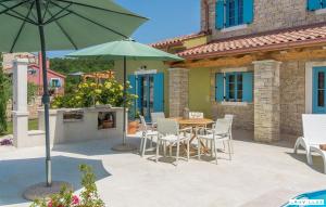 a patio with a table and chairs and an umbrella at Provence in Vilanija