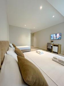 duży pokój z dwoma łóżkami i telewizorem na ścianie w obiekcie Solea Hotel we Wlorze