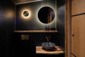 a bathroom with a bowl sink and a mirror at The Black Cabin Oban in Oban