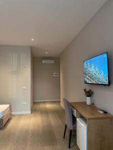 Pokój z biurkiem i telewizorem na ścianie w obiekcie Solea Hotel we Wlorze
