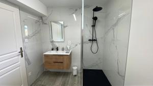 a white bathroom with a shower and a sink at Villa 4 Saisons, avec piscine chauffée et jacuzzi in Gérardmer +12 photos