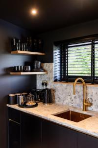 uma cozinha com um lavatório e uma bancada em The Black Cabin Oban em Oban