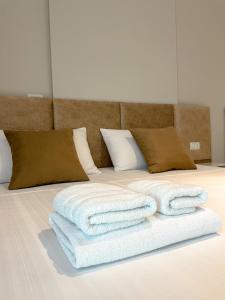 sterta ręczników na łóżku w obiekcie Solea Hotel we Wlorze