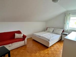 a bedroom with a bed and a red couch at Ferienwohnung zum Entspannen in Thalgau