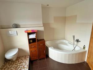 a bathroom with a tub and a toilet and a sink at Ferienwohnung zum Entspannen in Thalgau