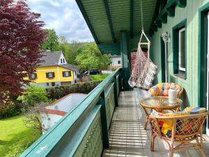 a porch with a hammock and a table and chairs at Ferienwohnung zum Entspannen in Thalgau