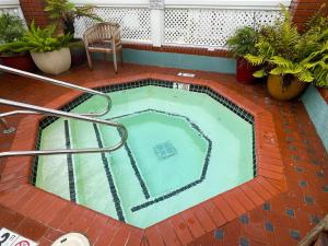 a small swimming pool on a patio with a chair at Inn On SummerHill in Summerland