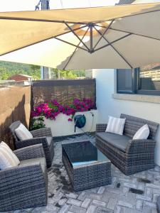 eine Terrasse mit 2 Stühlen und einem Sonnenschirm in der Unterkunft Casa Entrehorreos in Carnota