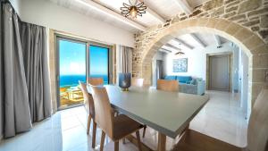 a dining room and living room with a table and chairs at Nafsika Xenia - Alkinoos Villa in Plátanos