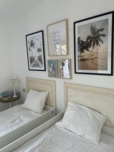 1 dormitorio con 2 camas y cuadros en la pared en Apartment with beautiful ocean view en Costa del Silencio