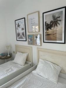 a bedroom with two beds and pictures on the wall at Apartment with beautiful ocean view in Costa Del Silencio