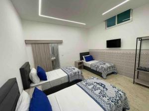 a hotel room with two beds and a television at Zaman Ya Zaman Boutique Hotel in Amman