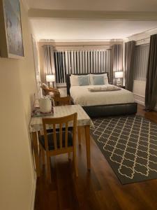 1 dormitorio con 1 cama, mesa y sillas en Heddfan - Peaceful Studio 5 mins from Stunning Llanbedrog Beach, en Pwllheli