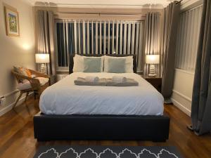 1 dormitorio con 1 cama grande y 2 toallas. en Heddfan - Peaceful Studio 5 mins from Stunning Llanbedrog Beach, en Pwllheli