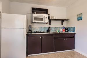 a kitchen with a white refrigerator and a microwave at Cottage Near Beach, Heated Pool, Full Kitchen! in Fort Myers
