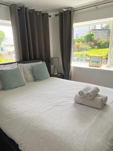 1 dormitorio con 1 cama grande y toallas. en Heddfan - Peaceful Studio 5 mins from Stunning Llanbedrog Beach, en Pwllheli