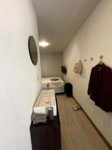 uma casa de banho com um lavatório e uma cama num quarto em Nina´s - Juan Santamaria em Alajuela