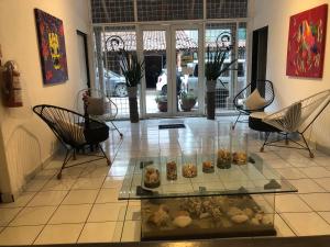 Cette chambre comprend des chaises et une table en verre avec des pâtisseries. dans l'établissement Hotel RHV, à Zihuatanejo