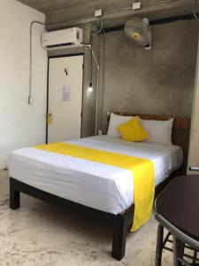 a bedroom with a large bed with a yellow blanket at Hotel RHV in Zihuatanejo