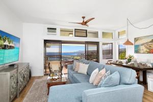 a living room with a blue couch and a table at K B M Resorts- KRV-2823 Large 1Bd with 180-degree ocean views perfect for whale watching in Kaanapali