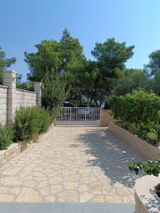 un cancello in un giardino con passerella in pietra di Anći a Sumartin