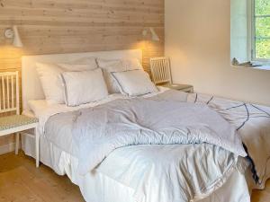 1 dormitorio con 1 cama grande con sábanas y almohadas blancas en 4 person holiday home in SKURUP en Skurup