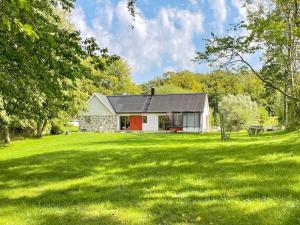 a house in a field with a green yard at 4 person holiday home in SKURUP in Skurup