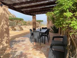 patio con tavolo e sedie sotto un pergolato di Casa Estrella a Almería