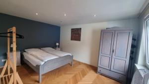 a bedroom with a bed and a cabinet at Sander's Apartments Landstuhl in Landstuhl