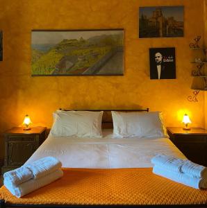 - une chambre avec un grand lit blanc et deux lampes dans l'établissement A Casa da Nonna Brasa Holiday Home Savoca, à Savoca