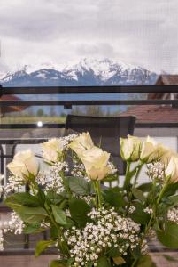 a bouquet of white roses in front of a window at Sun Valley Apartments in Maishofen