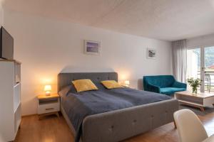 a bedroom with a bed and a blue chair at Sun Valley Apartments in Maishofen