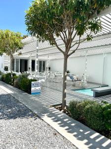 a building with a tree and a swimming pool at Relux Ios Hotel in Ios Chora