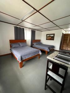 een kamer met twee bedden en een tafel erin bij MARIO in Alajuela