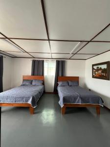 1 dormitorio con 2 camas y ventana en MARIO, en Alajuela