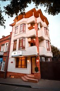 un edificio blanco alto con techo naranja en Hotel Well Inn, en Tiflis