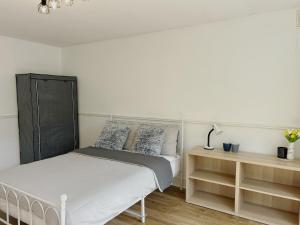 - une chambre blanche avec un lit et une table de nuit dans l'établissement Marlay Grange Luxury Guest House, à Dublin