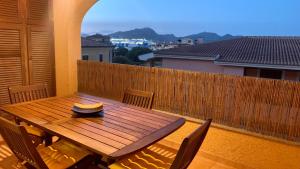 y balcón con mesa y sillas de madera. en Casa Sofia vista porto en Olbia
