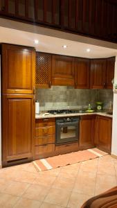 uma cozinha com armários de madeira e um forno com placa de fogão em Casa Sofia vista porto em Olbia