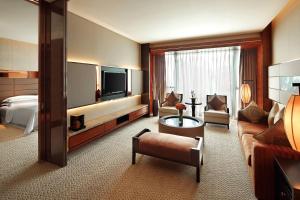 a large hotel room with a bed and a television at Sheraton Hefei Xinzhan Hotel in Hefei