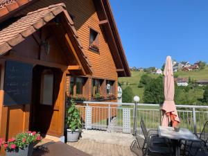 patio z parasolem, stołem i krzesłami w obiekcie Vogelbacher Hof - Dachsberg im Südschwarzwald 