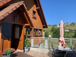 VogelbachにあるVogelbacher Hof - Dachsberg im Südschwarzwaldの傘とテーブルと椅子のあるパティオ