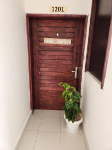 una pianta seduta davanti a una porta di legno di Mimi's Haven a Nairobi