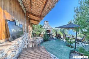 a house with a patio with a table and a fireplace at Stone in Murter