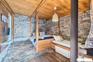 a room in a stone walled cabin with two beds at Stone in Murter