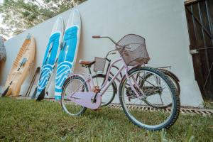 a pink bike parked in the grass next to surfboards at AmarBacalar in Bacalar