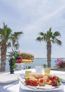 Acquamarina B&b في بورتو سيساريو: طاولة مع طبق من الطعام على الشاطئ