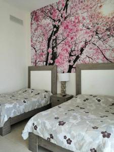 zwei Betten in einem Schlafzimmer mit einem Gemälde an der Wand in der Unterkunft Mayan Lakes Acapulco in Acapulco + 8 Fotos